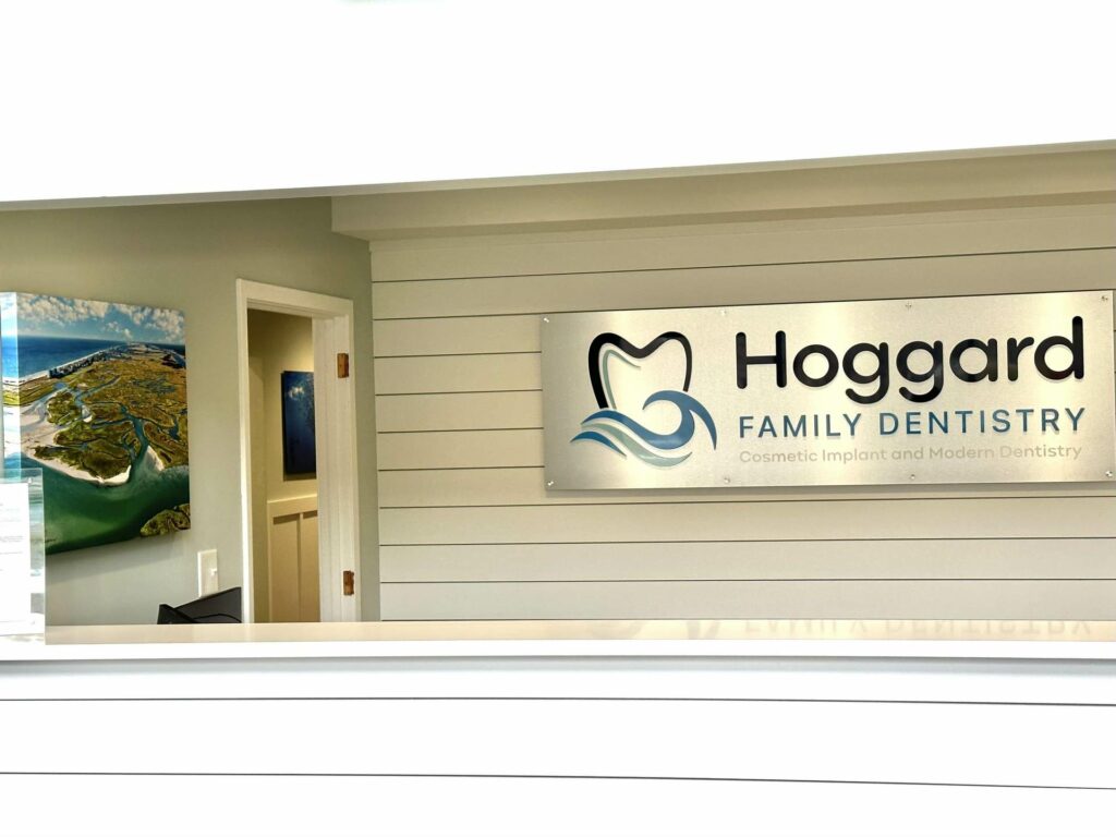 Our Team 22 Hoggard Family Dentistry front desk with logo on the wall