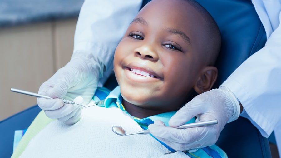 Children's Dentistry 1 a little boy showing his teeth during a dental check-up with a dentist