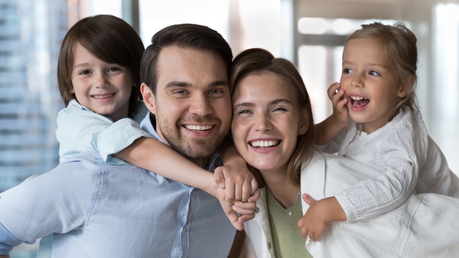 smiling family with kids on shoulders