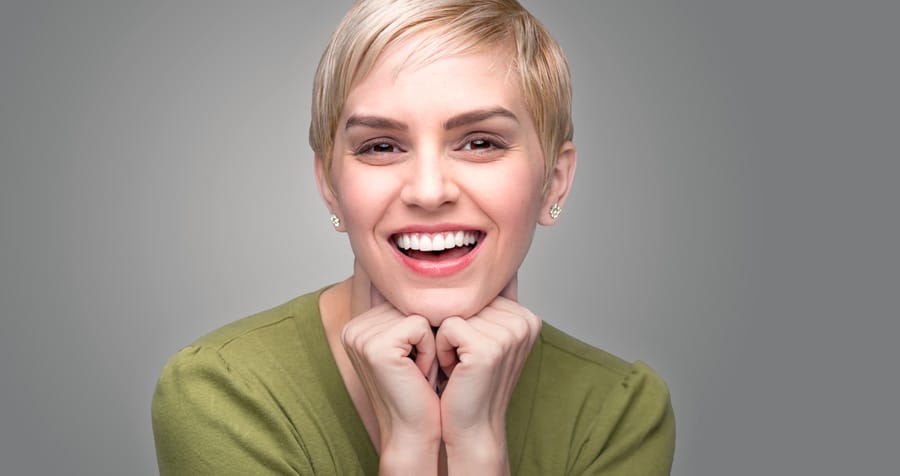 Same-Day Crowns 1 lady wearing a green blouse, showing her bright white smile